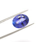 Close-up of a SAR Gems natural tanzanite gemstone, 7.65 carats, faceted oval cut, 11.5x14.5mm, showcasing violet-blue color and brilliant clarity.