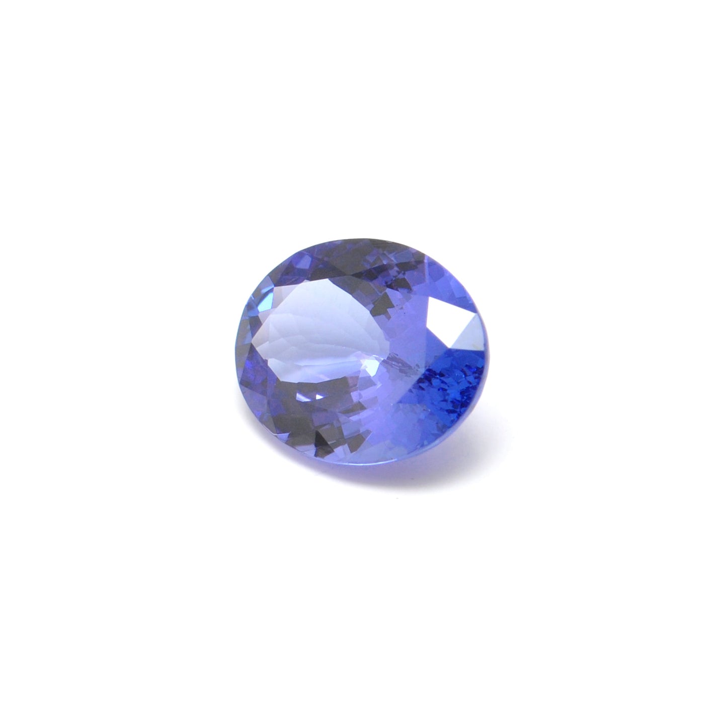 Close-up of a SAR Gems natural tanzanite gemstone, 7.65 carats, faceted oval cut, 11.5x14.5mm, showcasing violet-blue color and brilliant clarity.