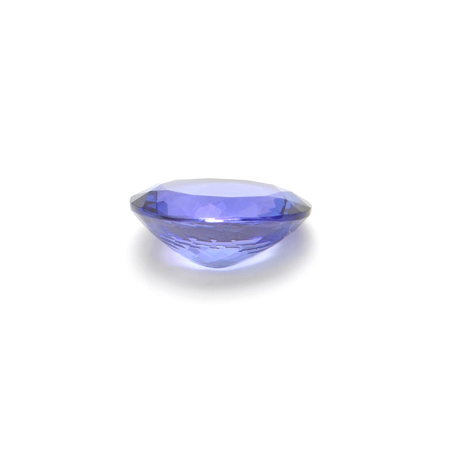 Close-up of a SAR Gems natural tanzanite gemstone, 7.65 carats, faceted oval cut, 11.5x14.5mm, showcasing violet-blue color and brilliant clarity.
