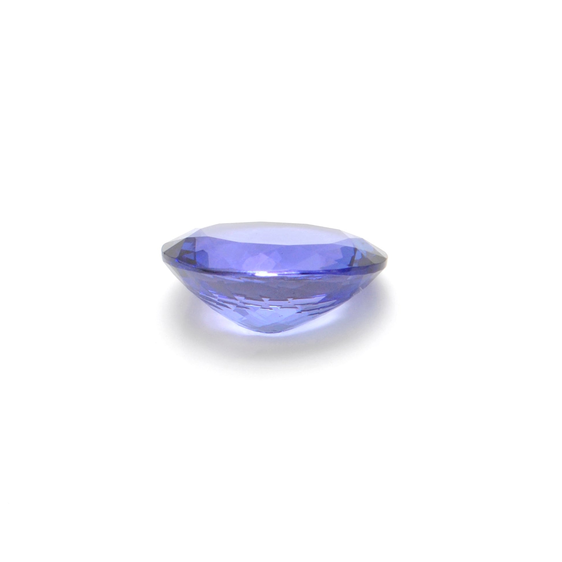 Close-up of a SAR Gems natural tanzanite gemstone, 7.65 carats, faceted oval cut, 11.5x14.5mm, showcasing violet-blue color and brilliant clarity.