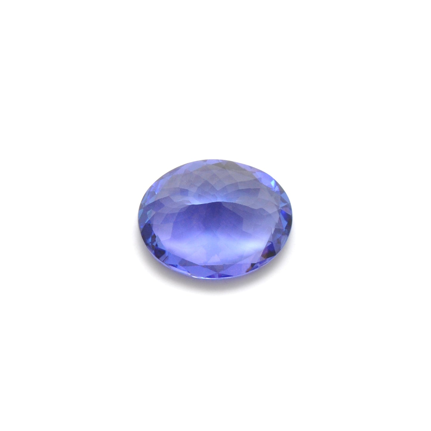 Close-up of a SAR Gems natural tanzanite gemstone, 7.65 carats, faceted oval cut, 11.5x14.5mm, showcasing violet-blue color and brilliant clarity.