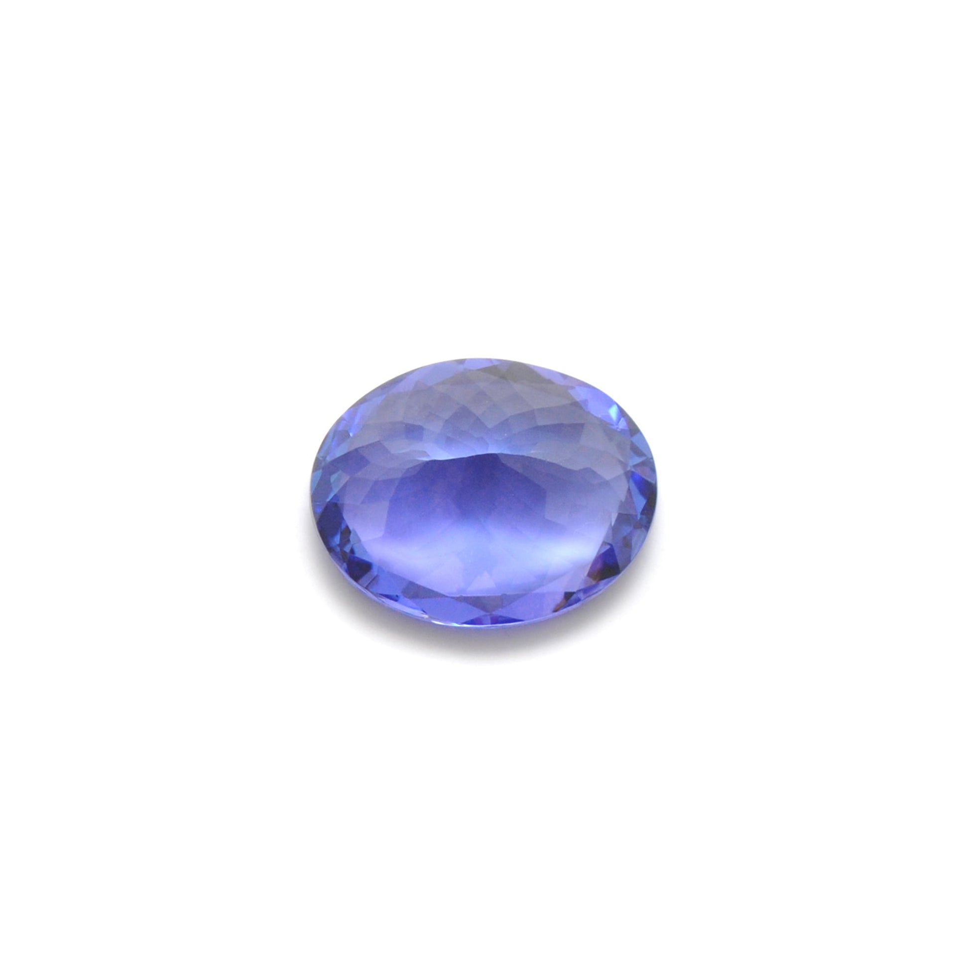 Close-up of a SAR Gems natural tanzanite gemstone, 7.65 carats, faceted oval cut, 11.5x14.5mm, showcasing violet-blue color and brilliant clarity.