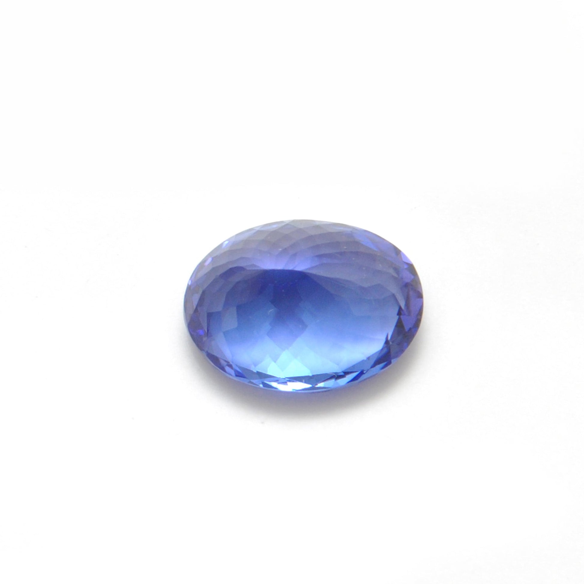 Close-up of a SAR Gems natural tanzanite gemstone, 6.25 carats, faceted oval cut, 6x10mm, showcasing violet-blue color and brilliant clarity