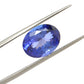 Close-up of a SAR Gems natural tanzanite gemstone, 6.25 carats, faceted oval cut, 6x10mm, showcasing violet-blue color and brilliant clarity