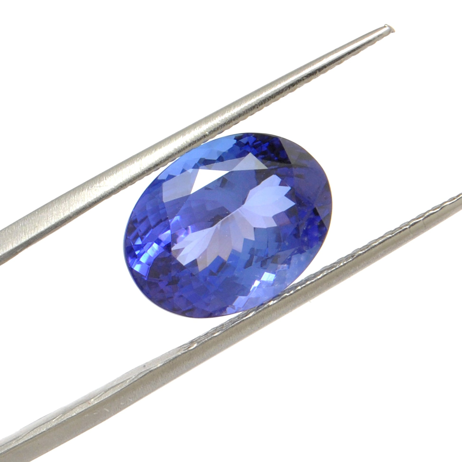 Close-up of a SAR Gems natural tanzanite gemstone, 6.25 carats, faceted oval cut, 6x10mm, showcasing violet-blue color and brilliant clarity