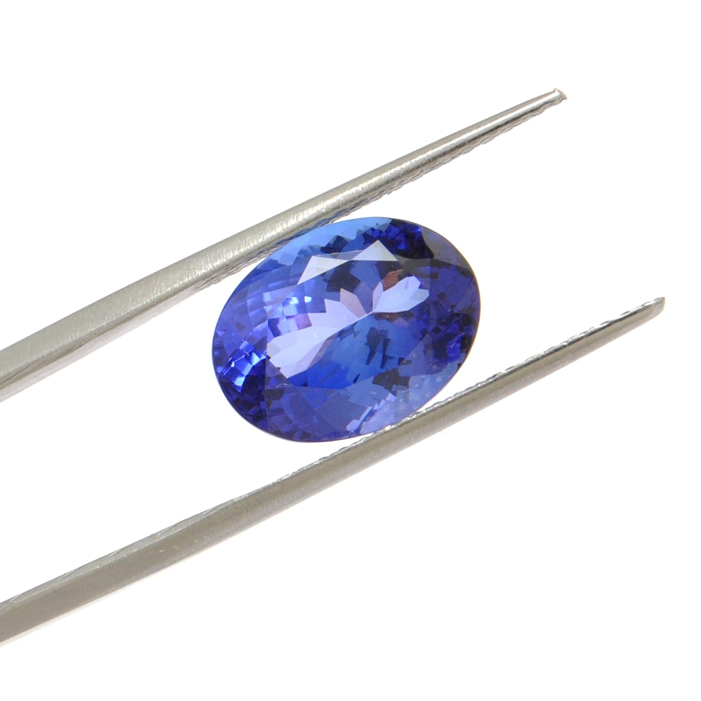 Close-up of a SAR Gems natural tanzanite gemstone, 6.25 carats, faceted oval cut, 6x10mm, showcasing violet-blue color and brilliant clarity