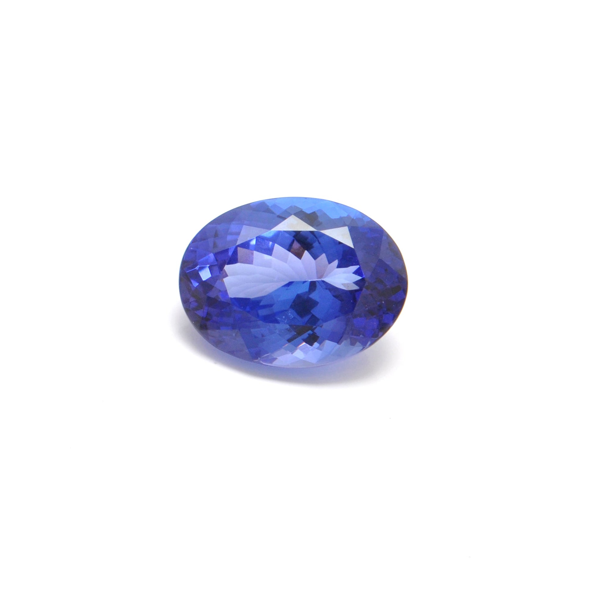 Close-up of a SAR Gems natural tanzanite gemstone, 6.25 carats, faceted oval cut, 6x10mm, showcasing violet-blue color and brilliant clarity