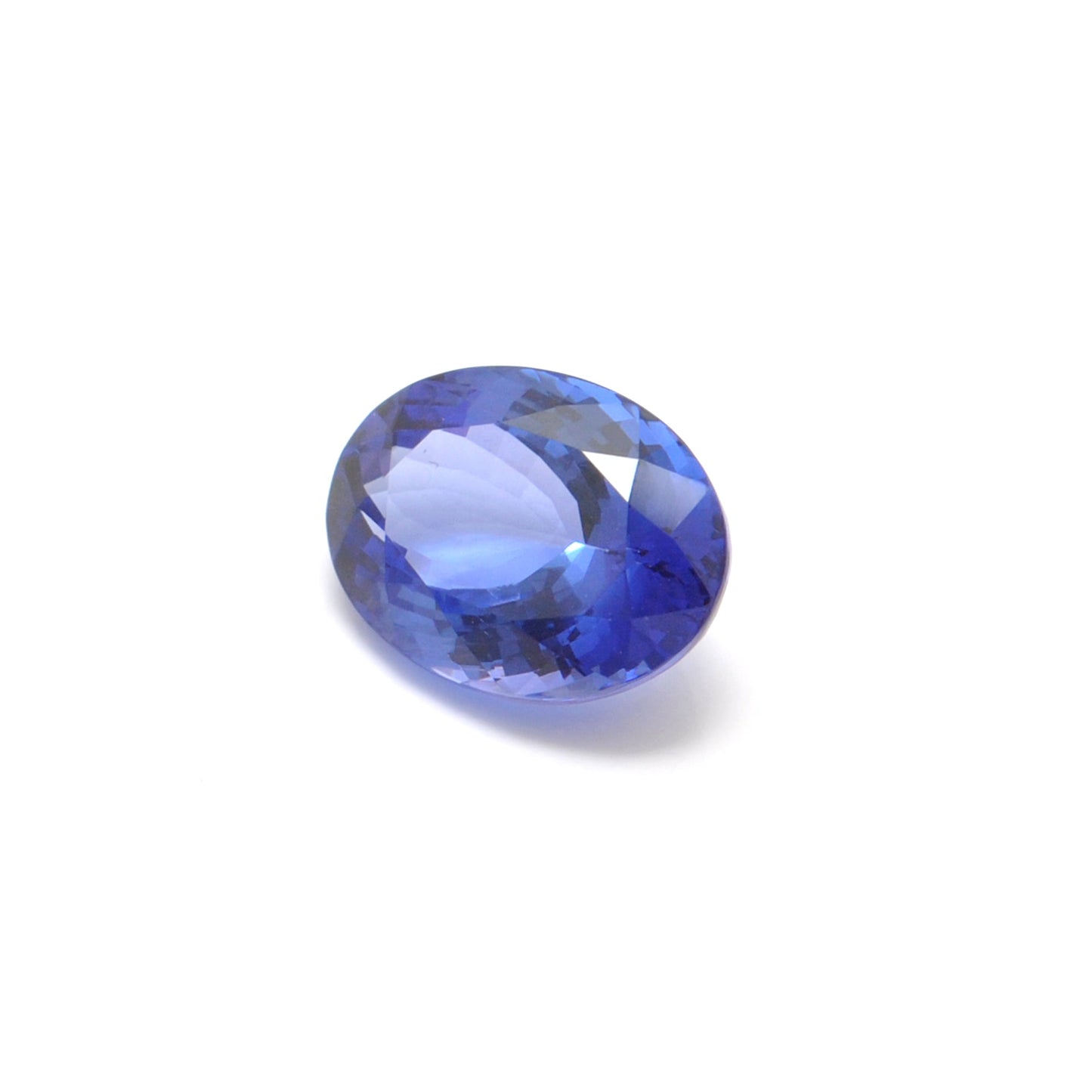 Close-up of a SAR Gems natural tanzanite gemstone, 6.25 carats, faceted oval cut, 6x10mm, showcasing violet-blue color and brilliant clarity