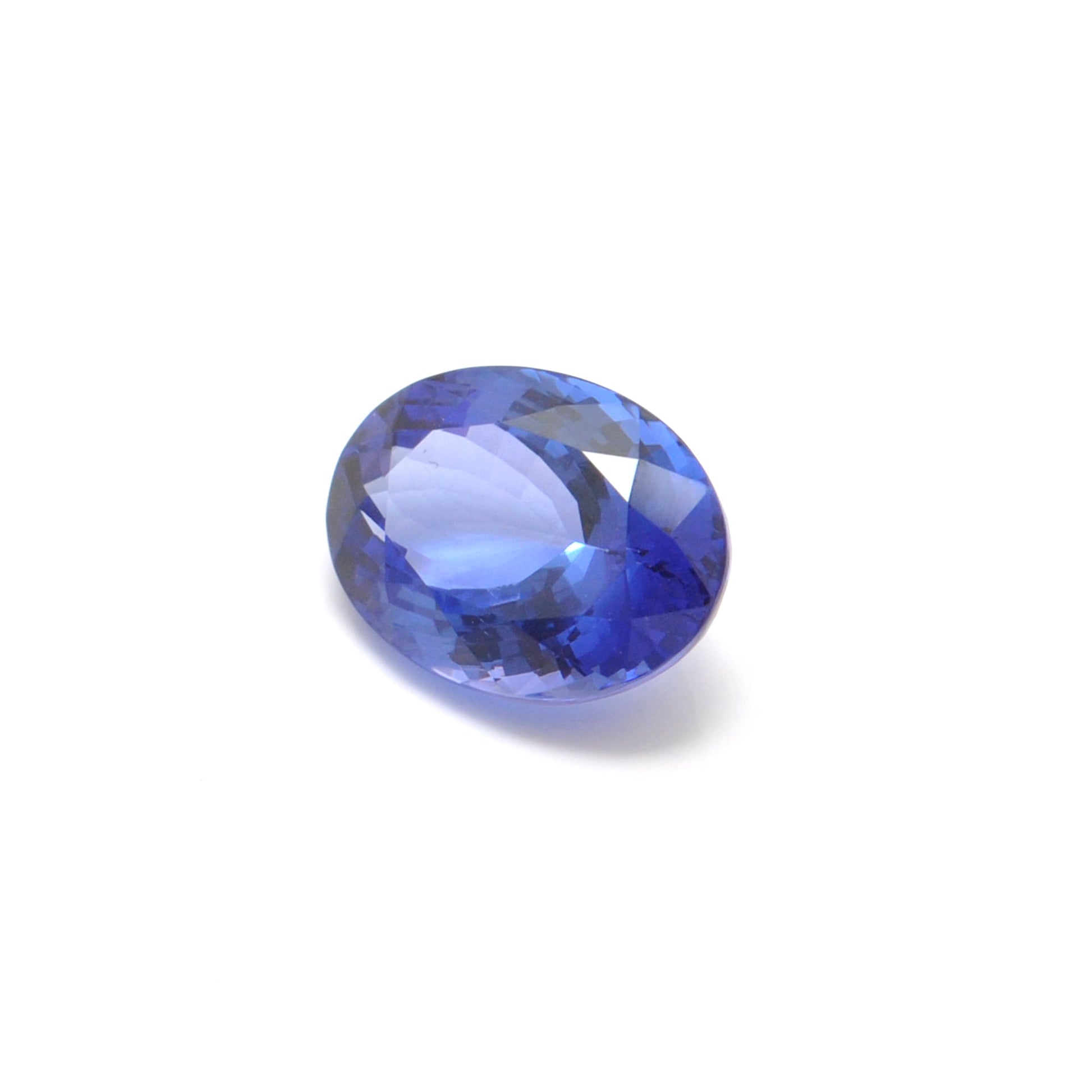 Close-up of a SAR Gems natural tanzanite gemstone, 6.25 carats, faceted oval cut, 6x10mm, showcasing violet-blue color and brilliant clarity