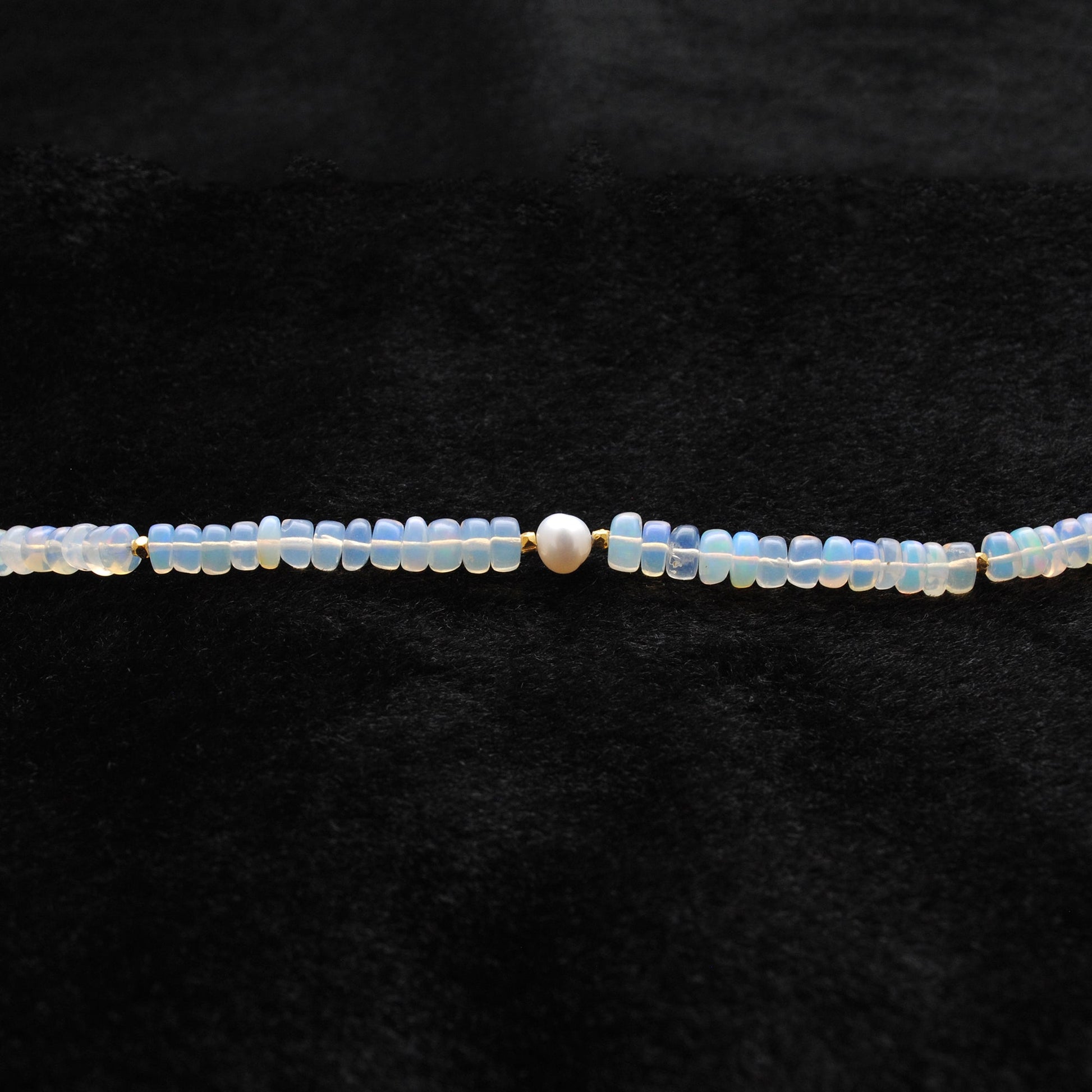 Beaded Necklace featuring 925 Sterling Silver, Opal beads, and Freshwater Pearl centerpiece on a black background.